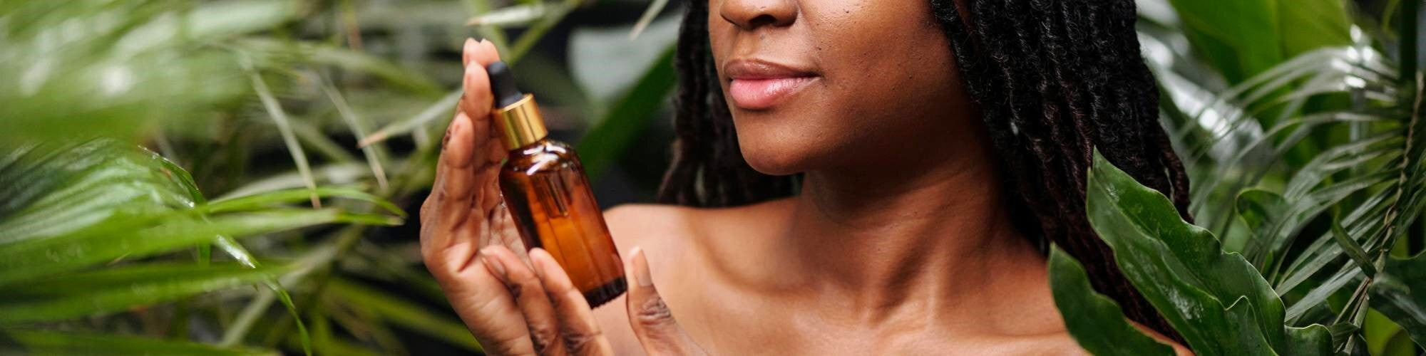 Woman holding a bottle of oil with a natural background